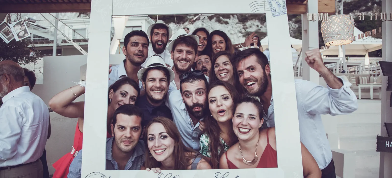 καλεσμένοι ποζάρουν σε photobooth γάμου